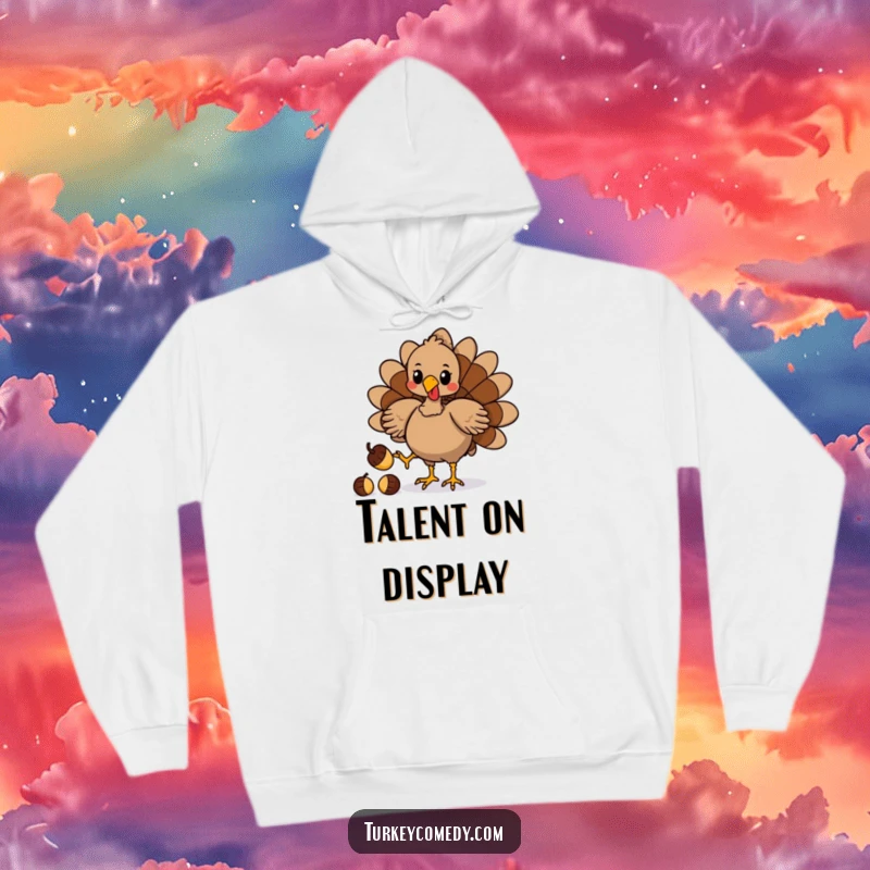 Funny hoodie showcasing a playful turkey character masterfully juggling acorns with its feet, a humorous and impressive display.